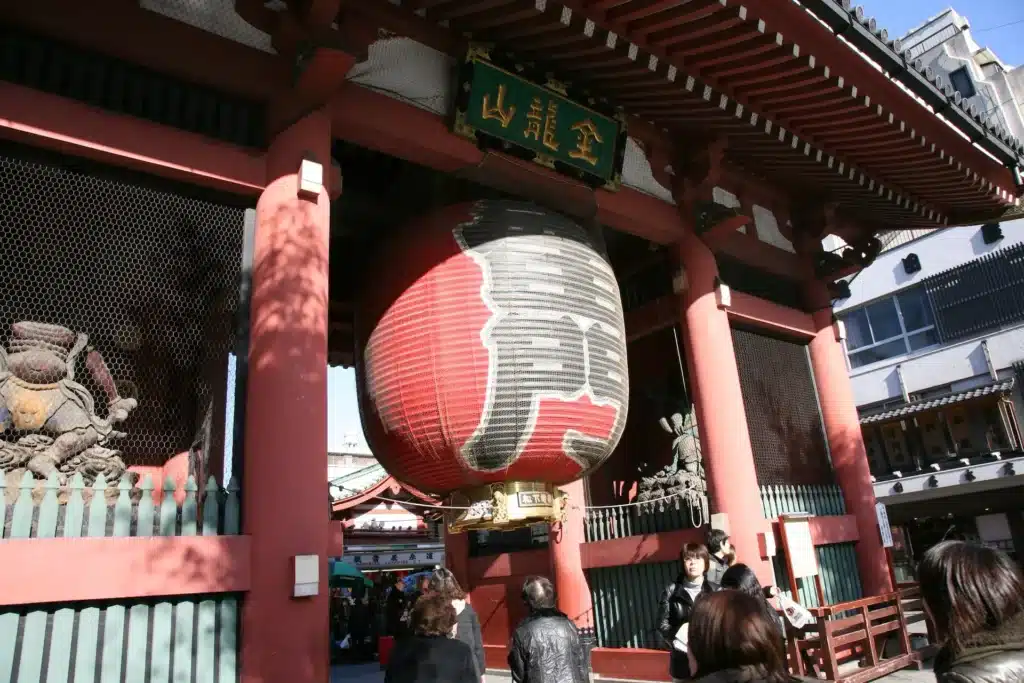 雷門白天景象,旅客經過巨大紅燈籠與風雷神像