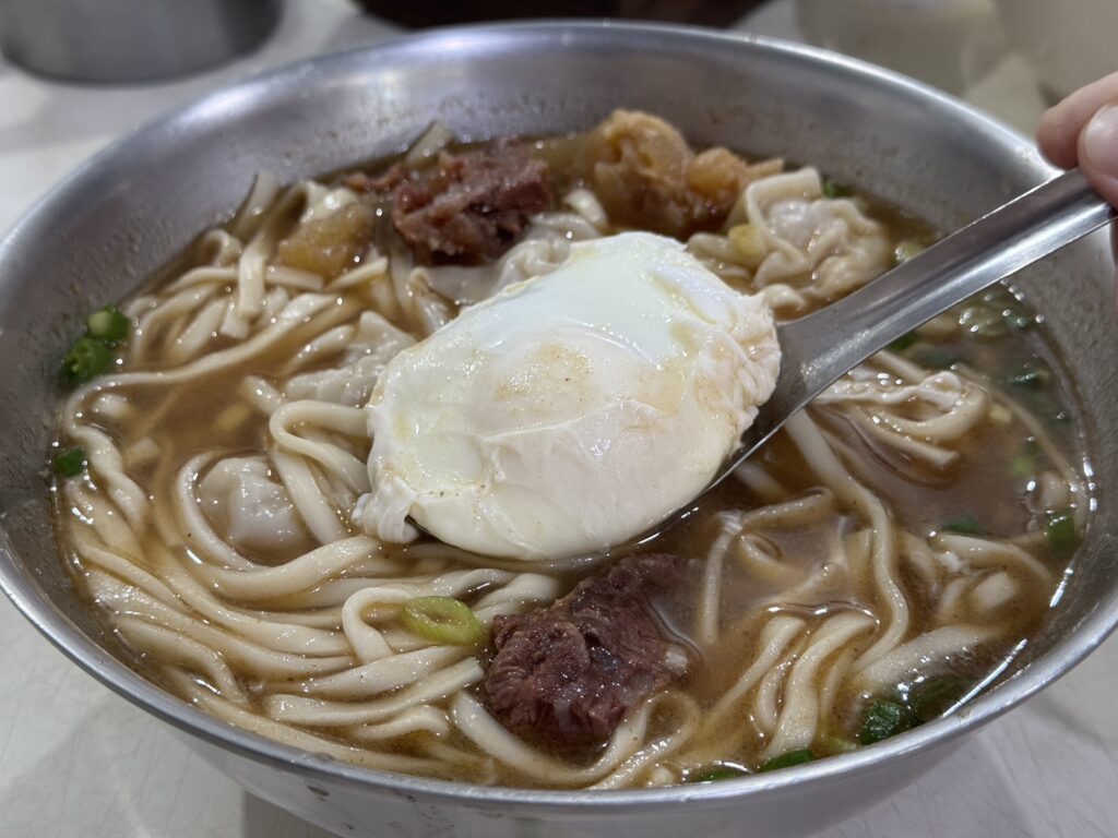 半熟蛋搭配半筋半肉麵，蛋黃完整，為湯麵增添層次。