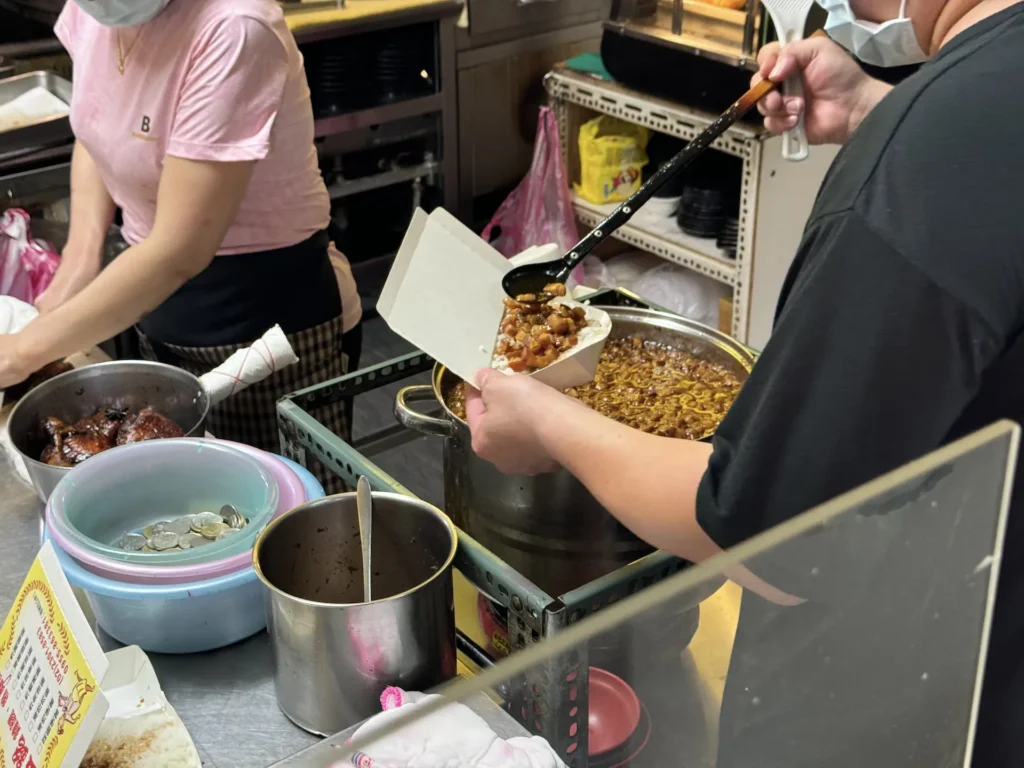 金銘雞腿魯肉飯的大碗滷肉飯打包中。