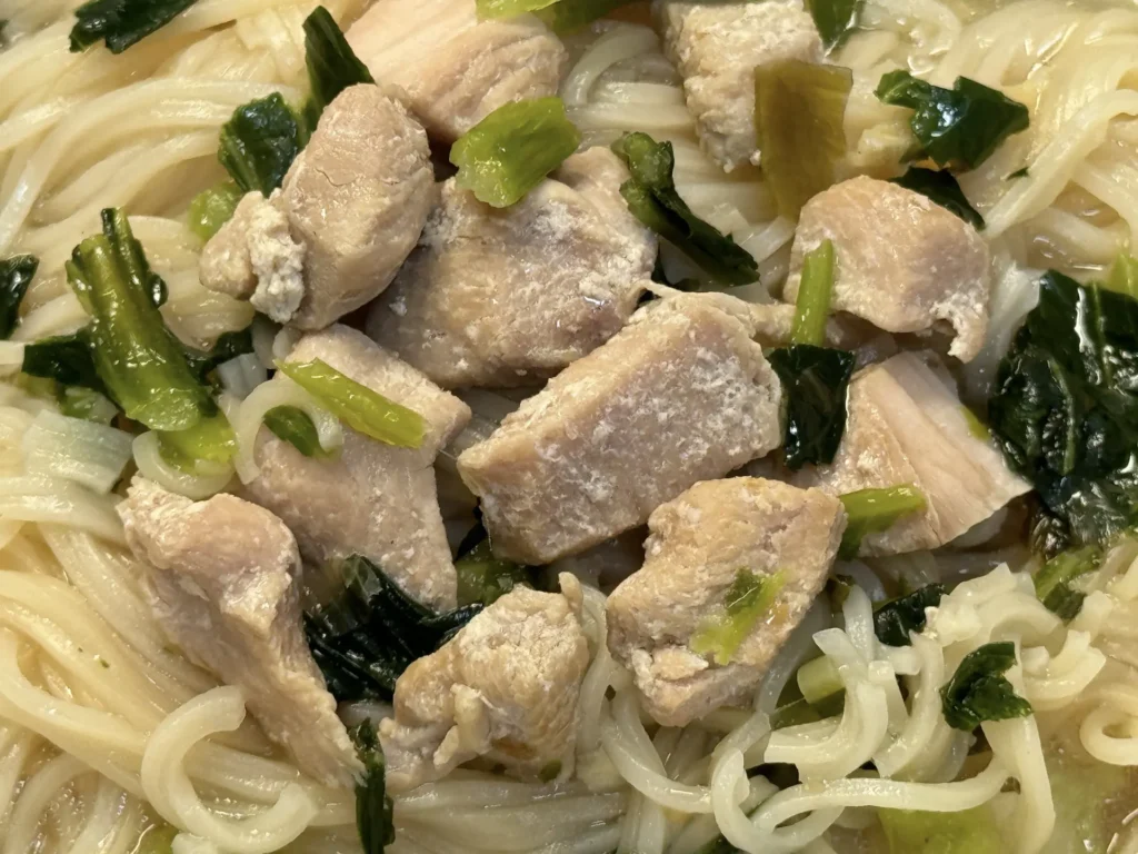 台酒紹興雪菜雞肉麵的雞肉塊與青菜特寫