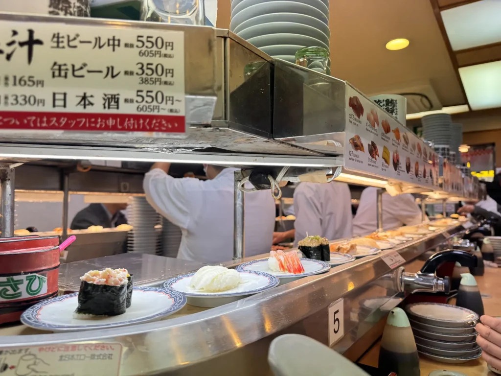 新橋傳統迴轉壽司店內師傅捏製壽司畫面