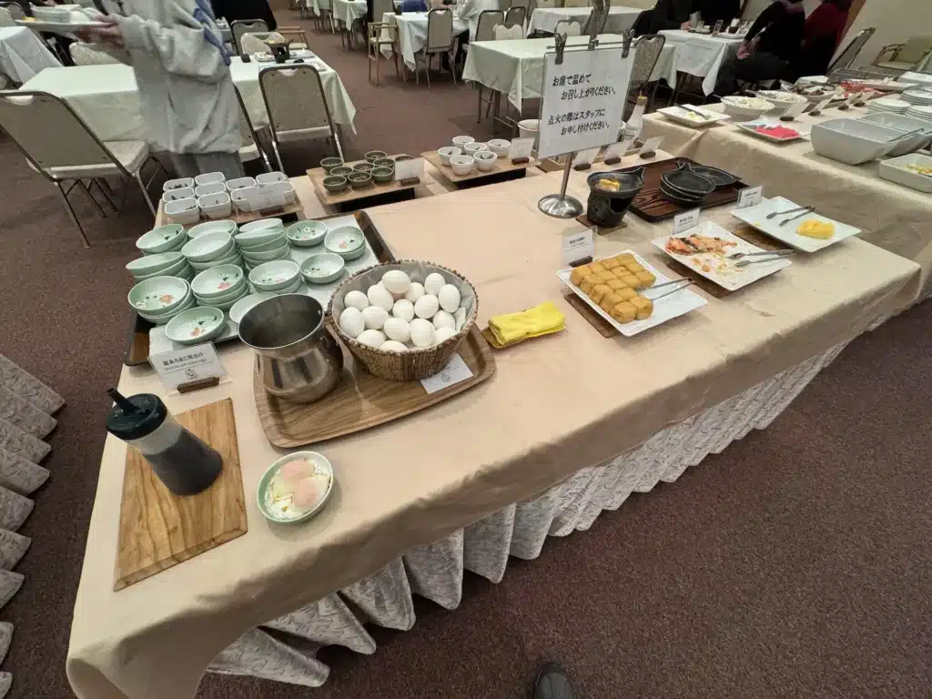 湯澤東映飯店早餐蛋料理區，提供生雞蛋、溫泉蛋、烤鮭魚、玉子燒、油豆腐等定番日式菜色。