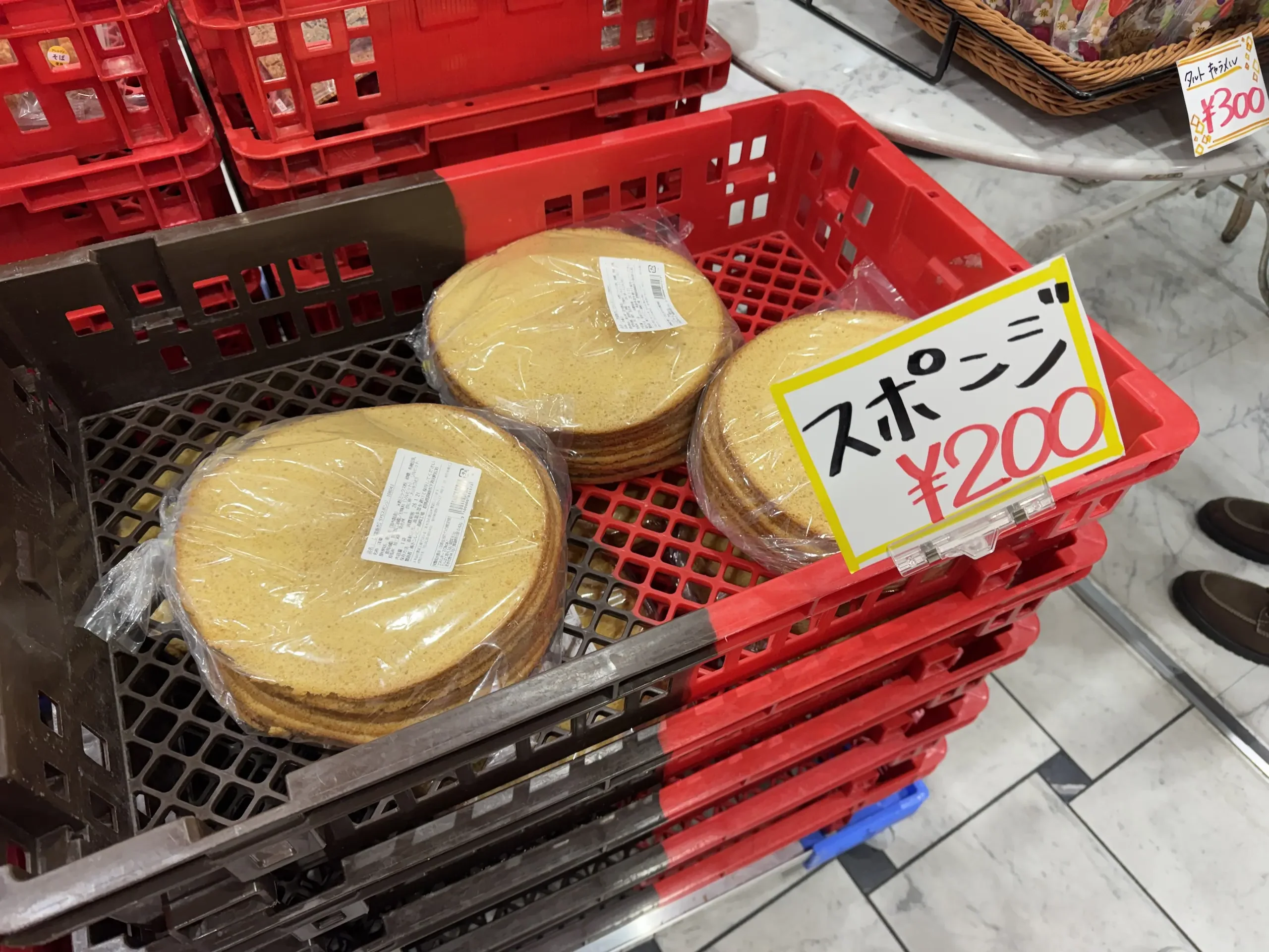 一袋袋裝好的海綿蛋糕胚(スポンジ)擺在紅色籃子裡,價格只要 200 日圓。
