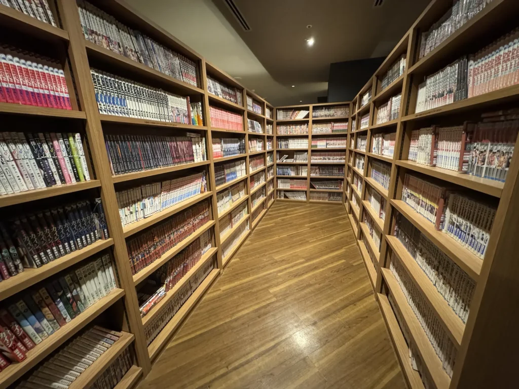 Dormy Inn 漫畫區,整排書櫃與木地板閱讀空間