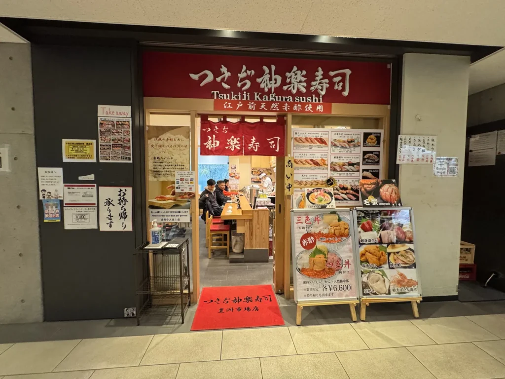 つきぢ神楽寿司豐洲店外觀,門口展示三色丼、赤身丼、多種海鮮丼的大型海報。