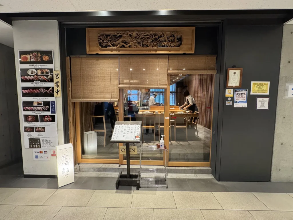 豐洲市場內的市場すし店面,木質拉門設計,可見師傅在壽司檯前工作。