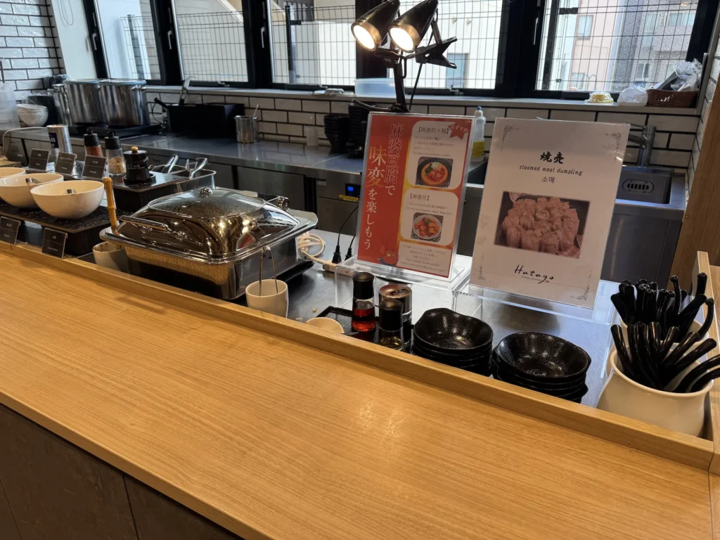 Dormy Inn 川崎早餐自助吧台熱食區,保溫餐盤與燒賣展示牌,現場提供蒸肉燒賣與多樣日式配菜