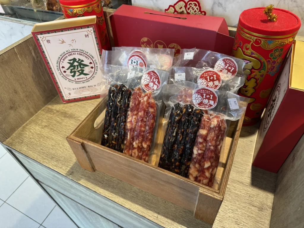 1+1 燒臘的臘腸禮盒展示，木箱裡裝著臘腸與肝腸