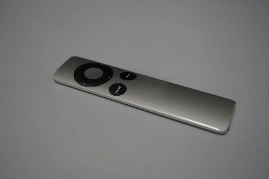 Apple TV 鋁製 Apple Remote 遙控器正面，方向鍵、MENU 與播放鍵