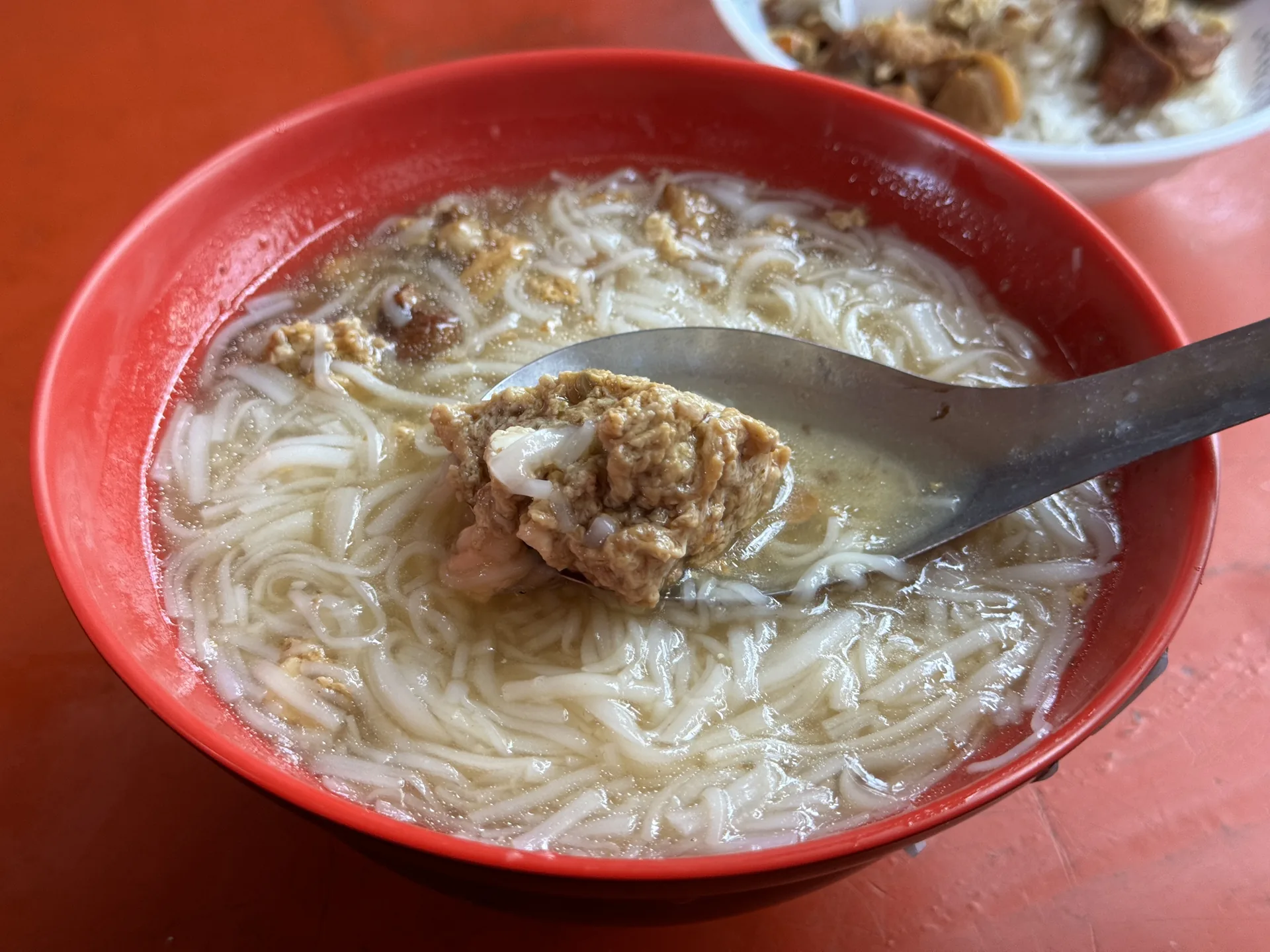 老等油飯的麵線糊用湯匙舀起，可見麵線與滷蛋白