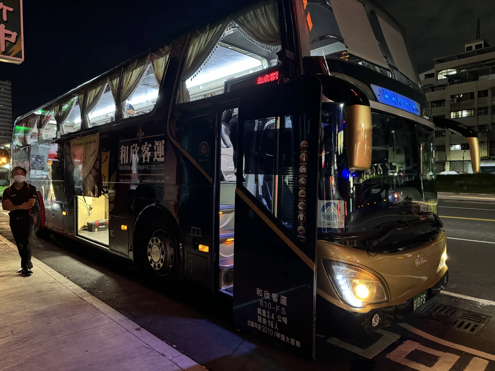 和欣客運的遊覽車停在夜晚的站牌前準備發車