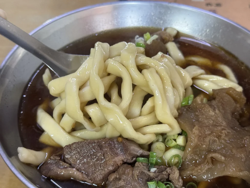 筷子夾起老熊牛肉麵超粗的家常麵