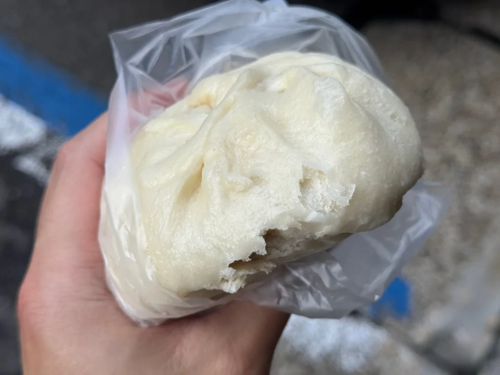 手拿著咬了一口的妙口肉包