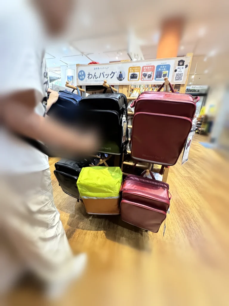 日本 mont-bell 門市的 montbell書包展示架,黑、深藍、酒紅與黃色雨罩款並排