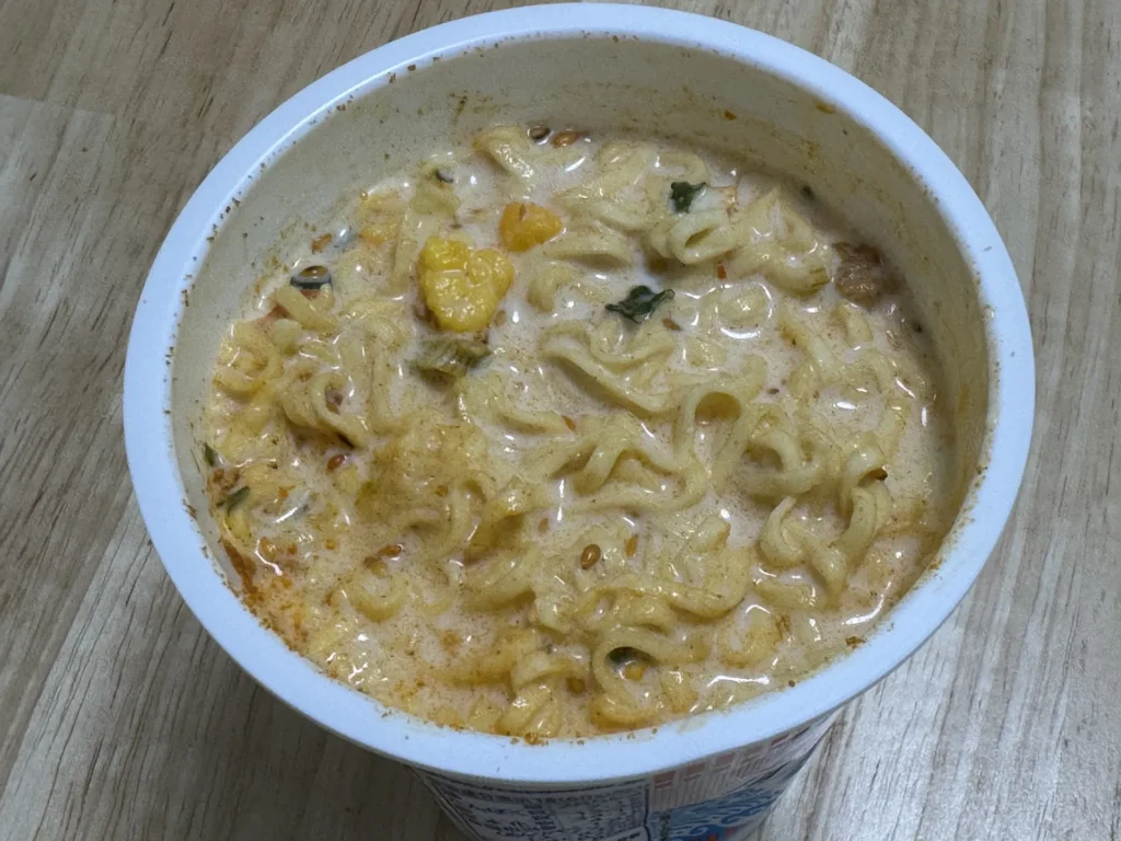 用牛奶泡好的日清冷水泡麵,湯是奶白帶一點橘紅