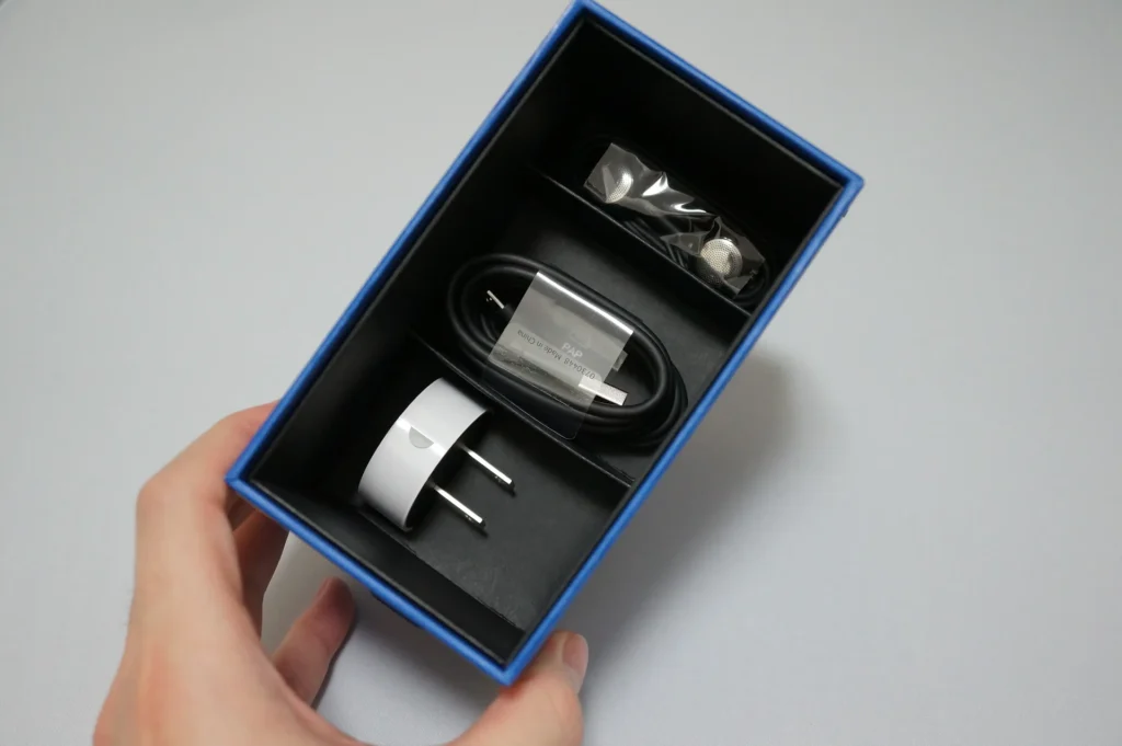 打開 Nokia Lumia 800 配件盒，裡面有充電器、USB 線與耳機