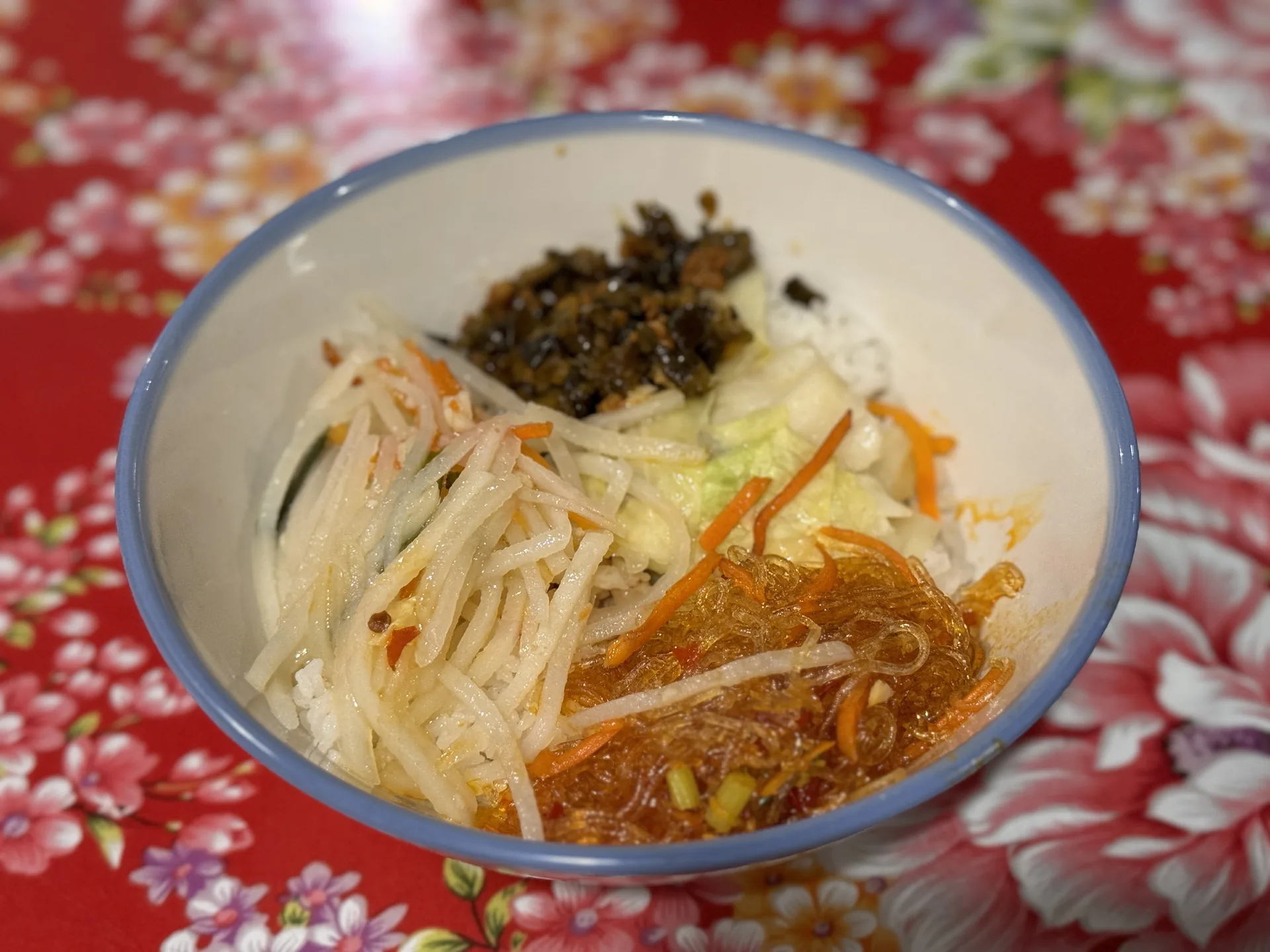 台生飲食亭大碗裡的配菜，有馬鈴薯絲、酸菜、冬粉與辣蘿蔔