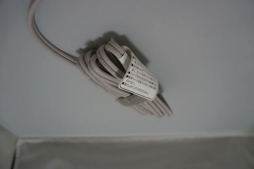 TESCOM 吹風機電源線用魔鬼氈束起,掛著日文注意吊牌