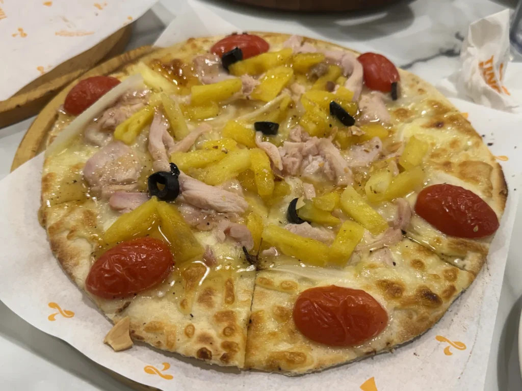 Tino's Pizza 的火烤夏威夷 10 吋薄片,鳳梨、雞肉、黑橄欖與小番茄
