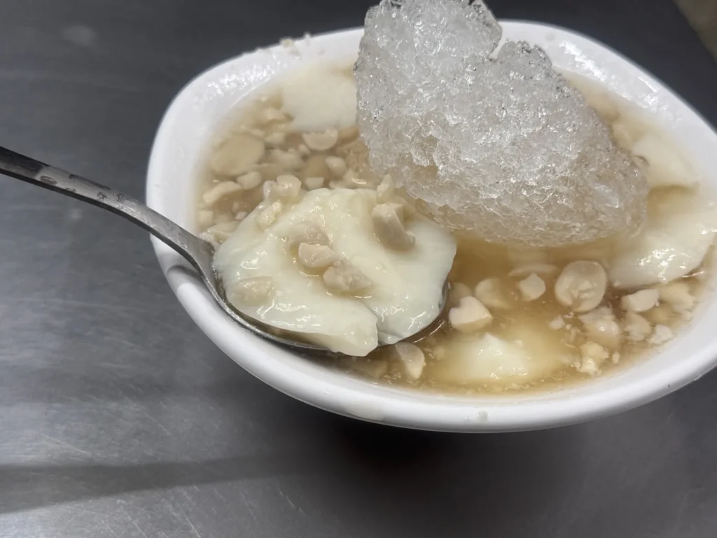 湯匙舀起阿伯阿嬤湯圓滑嫩的豆花