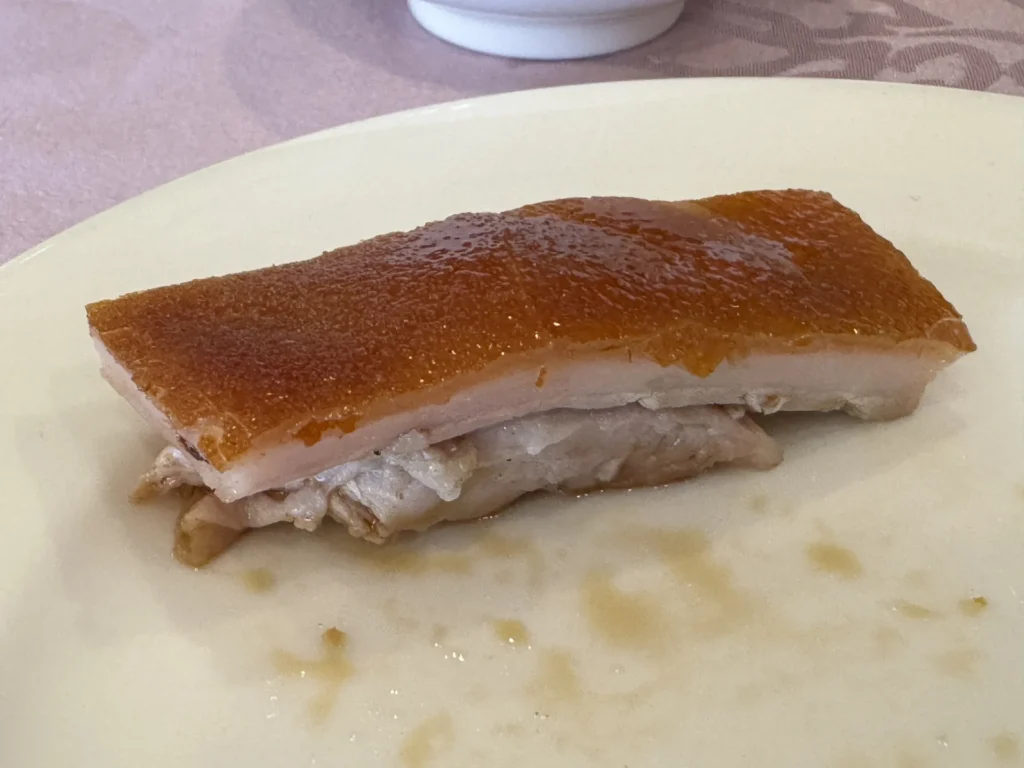 圓山大飯店金龍餐廳炭燒乳豬特寫,金黃色的脆皮與肉層