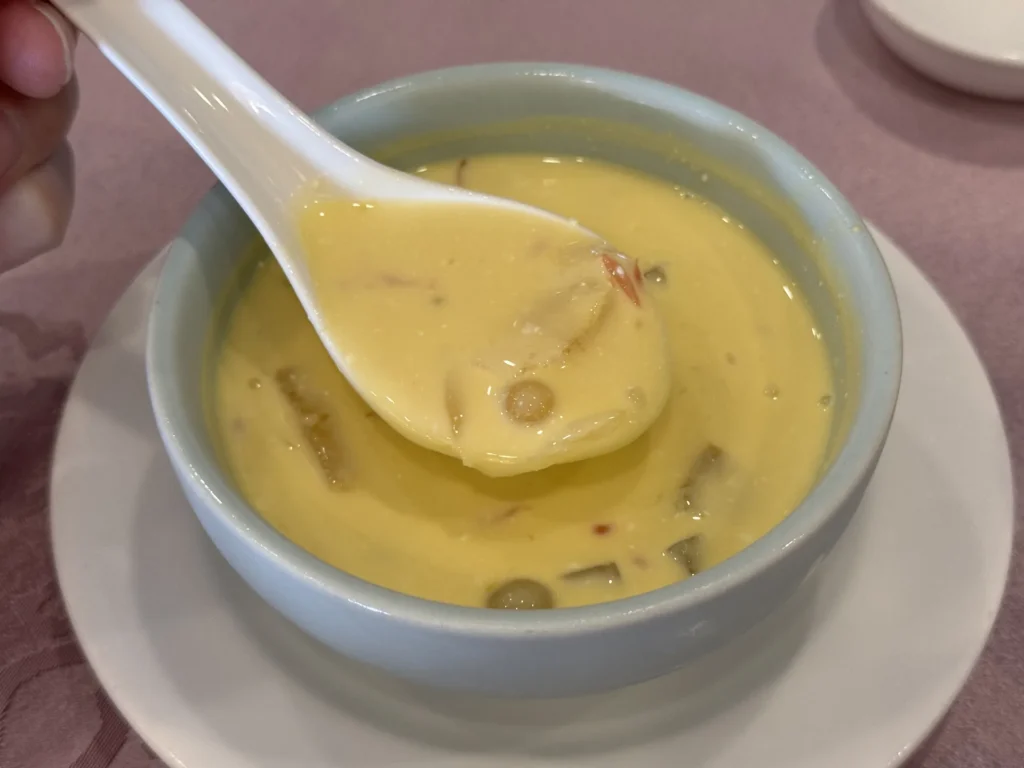 圓山大飯店金龍餐廳的楊枝甘露,湯匙舀起黃澄澄的芒果甜湯