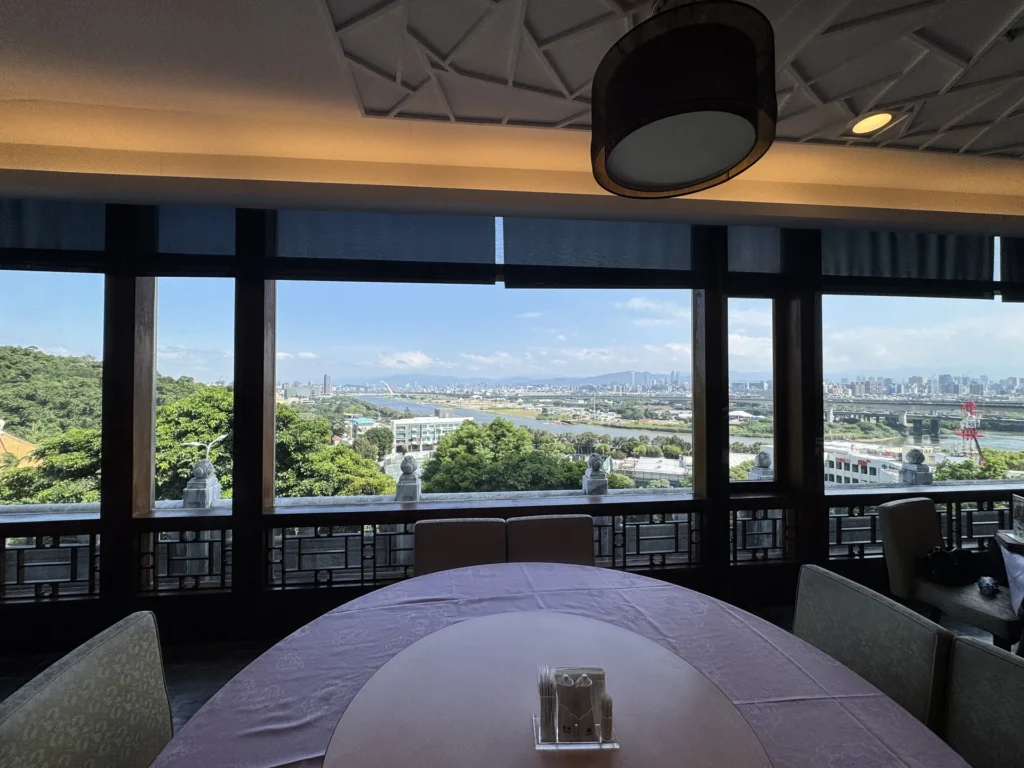 圓山大飯店金龍餐廳窗邊座位,窗外是基隆河與城市景色
