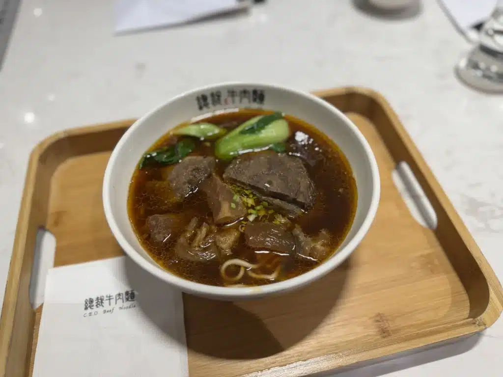 總裁牛肉麵的半斤半肉麵，紅褐湯頭配牛肉塊與青江菜