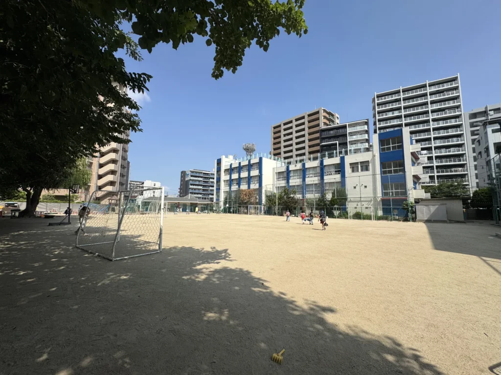 大阪 YMCA 國際學校的操場,夏天的大太陽下有小朋友在玩