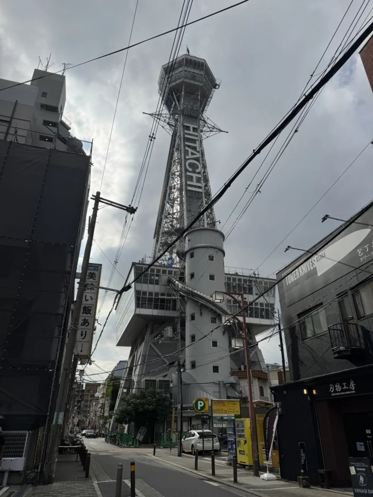 從街道往上看通天閣,塔身寫著 HITACHI