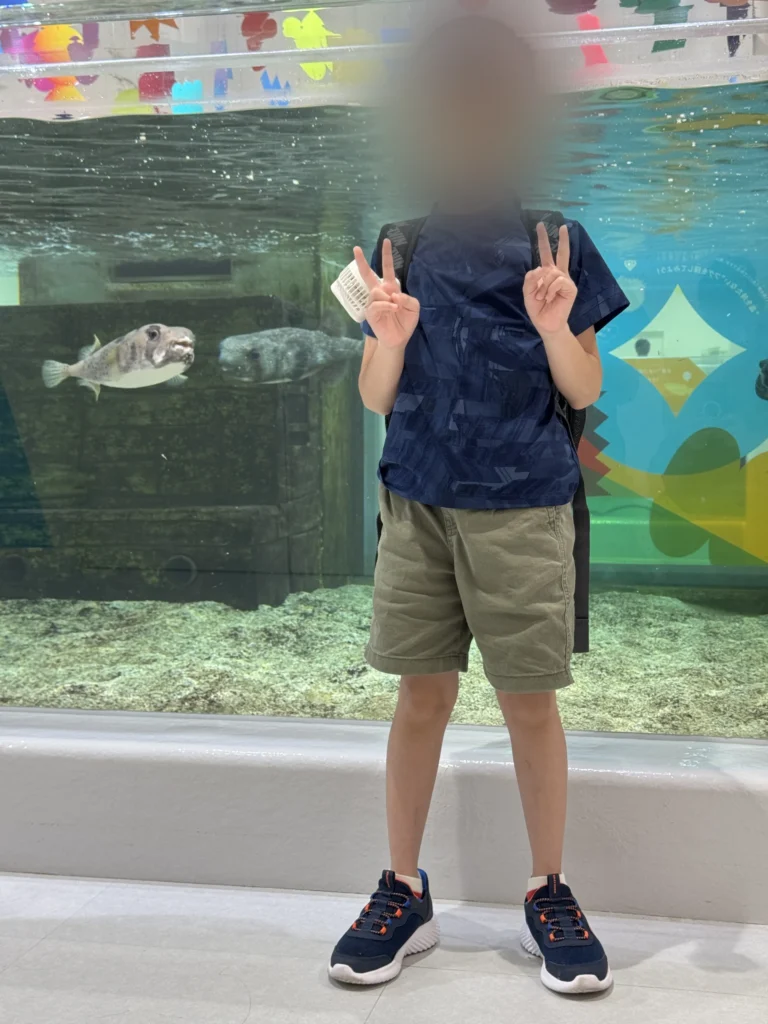 NIFREL 的魚缸前,弟弟比 YA,後面有河豚