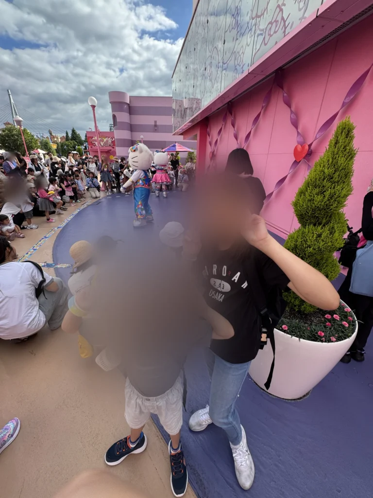 環球影城 Hello Kitty 區的粉紅色建築前，姐弟合照