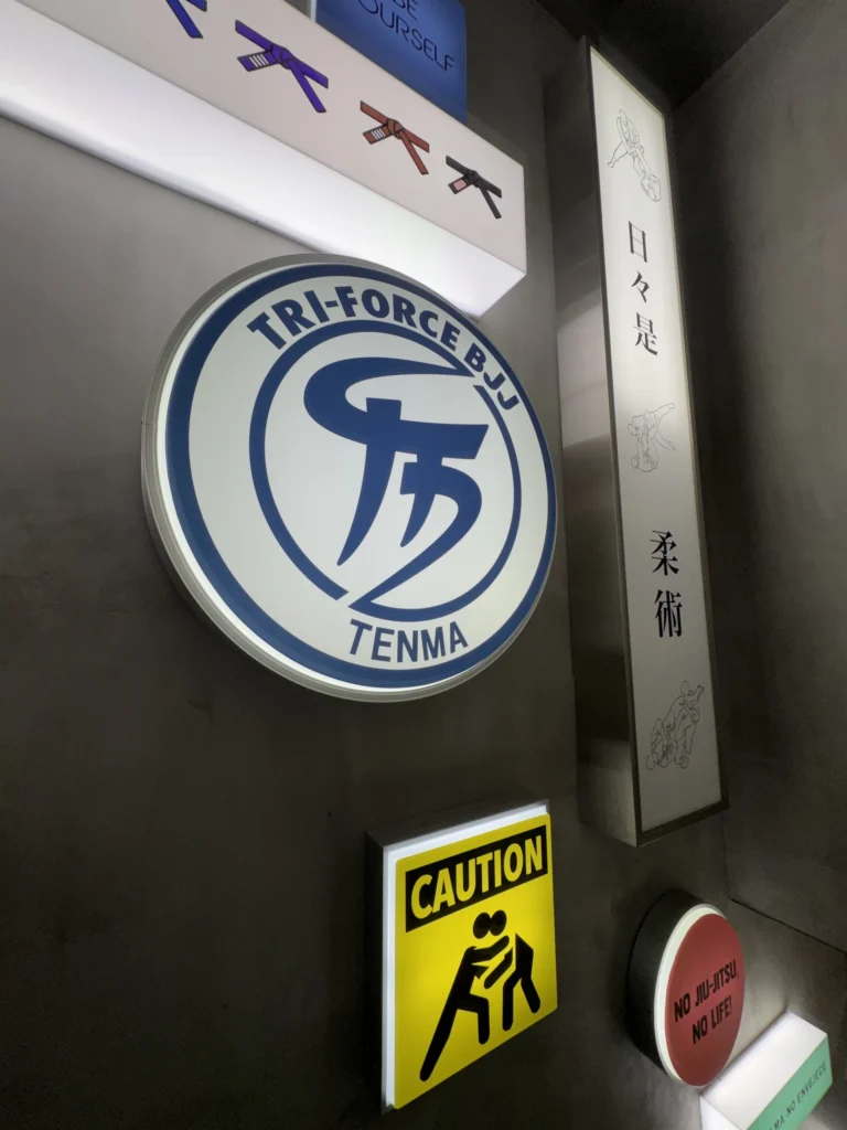 トライフォース天満門口的招牌，寫著 TRI-FORCE BJJ TENMA