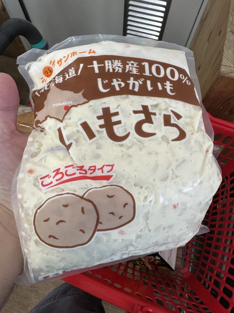 手上拿著一包いもさら,寫著北海道十勝產 100% 馬鈴薯