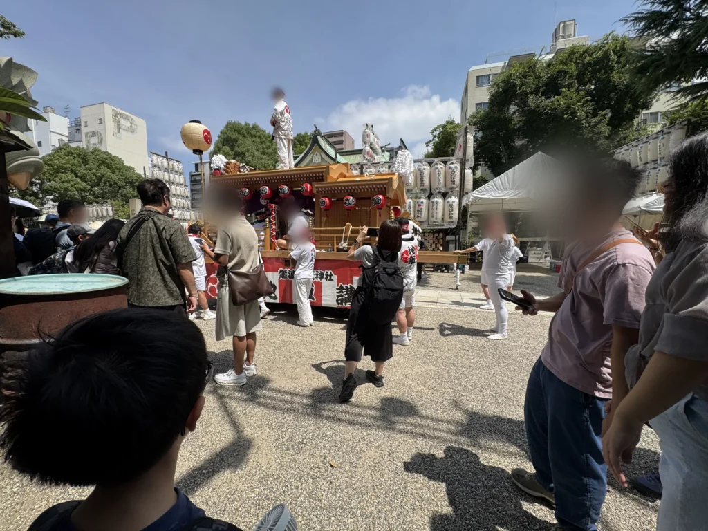 難波八阪神社夏祭，穿白衣的人推著掛紅燈籠的太鼓台準備出發