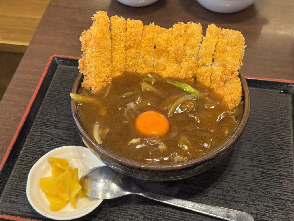 日本橋 まる榮的炸豬排咖哩蓋飯，中間有一顆生蛋黃