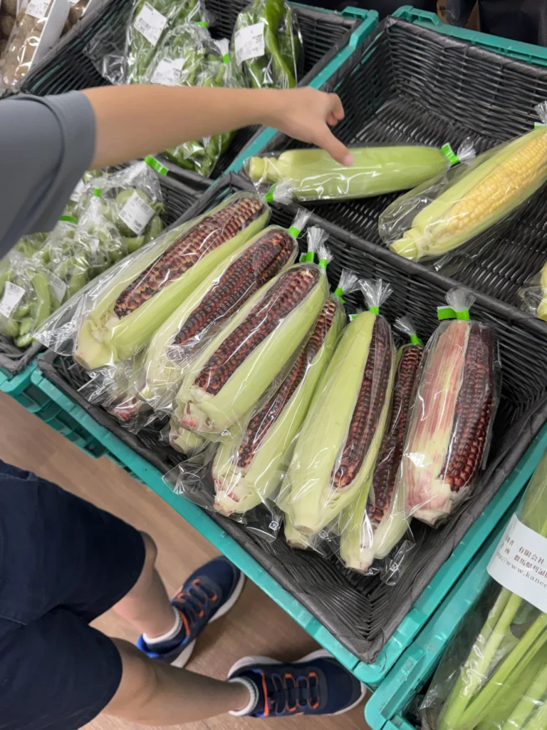 業務用超市蔬菜區，一整箱帶殼的玉米