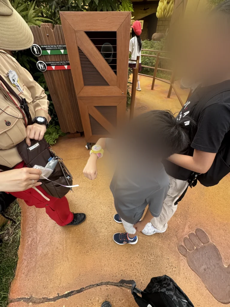 咚奇剛的瘋狂礦車入口，工作人員幫小孩量身高