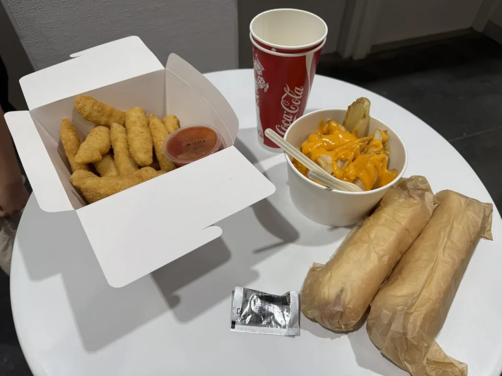 門真 Outlet 隔壁 Costco 用餐區的桌上,有熱狗、炸雞條、起司醬薯條和可樂
