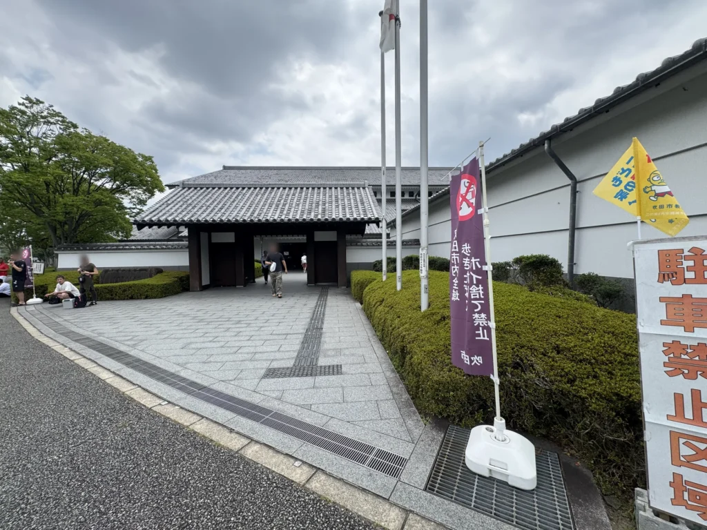 吹田市立武道館的入口，日式屋頂的大門和旁邊的旗子