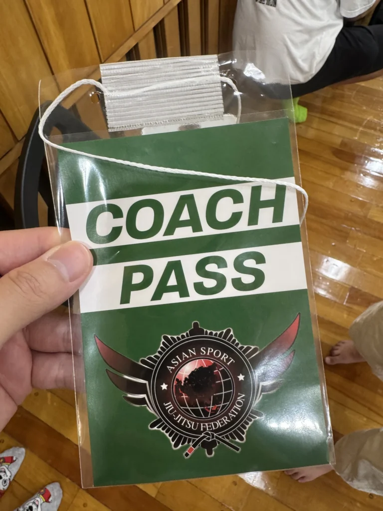 綠色的 COACH PASS 教練證,上面有亞洲運動柔術聯盟的標誌