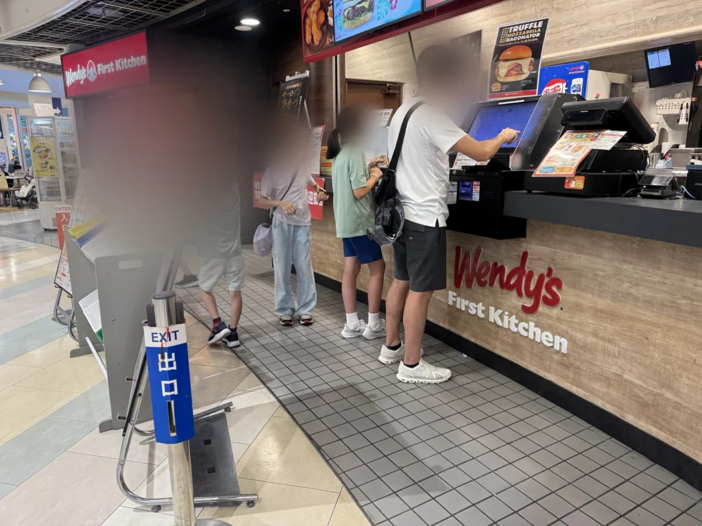 離開海遊館後，商場裡的 Wendy's First Kitchen 櫃台，大家在點餐