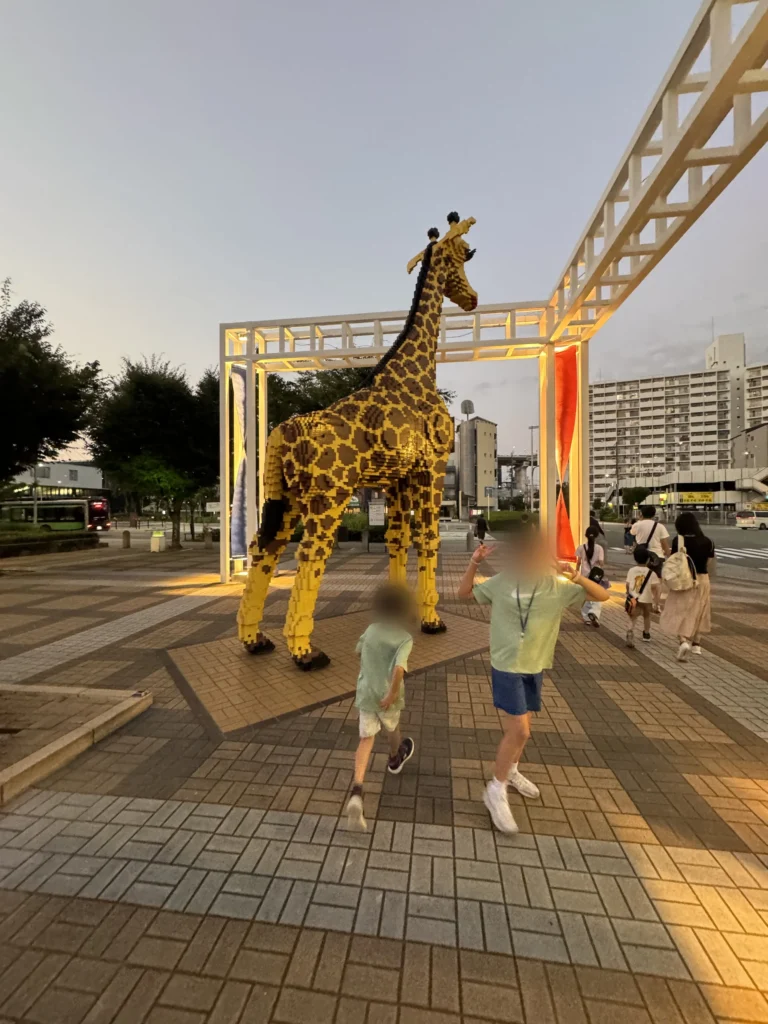 海遊館外面廣場的大型長頸鹿裝置，小孩們在前面跑