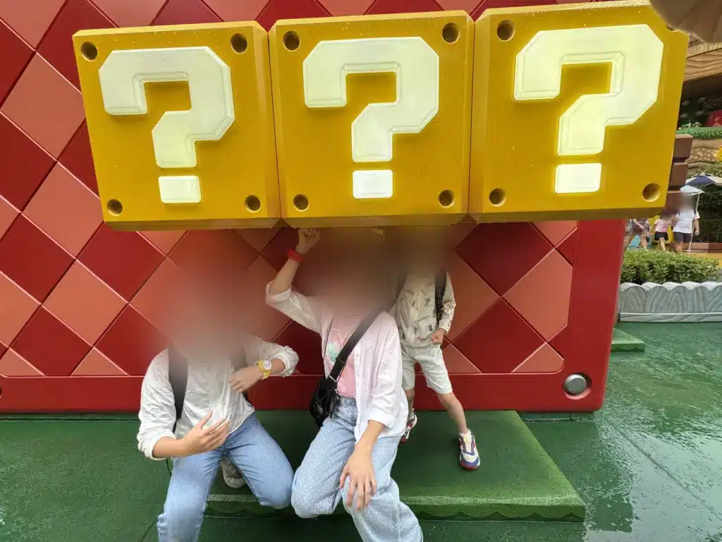 超級任天堂世界的問號方塊前，小孩擺姿勢拍照