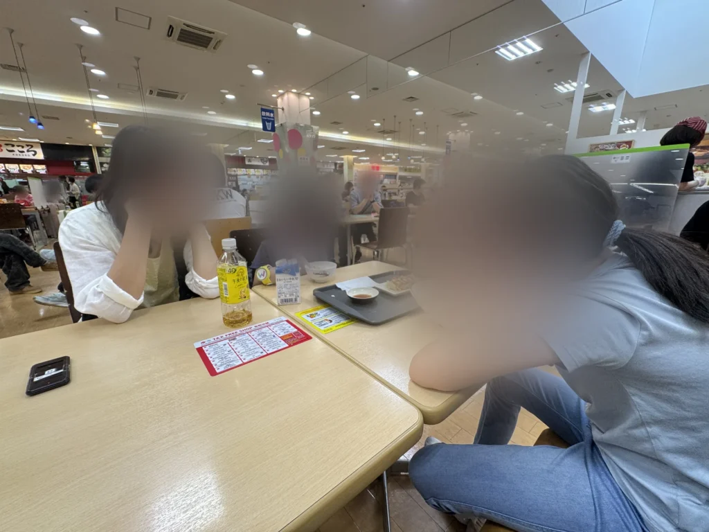 臨空城 Outlet 前的美食街，家人坐在座位上吃午餐