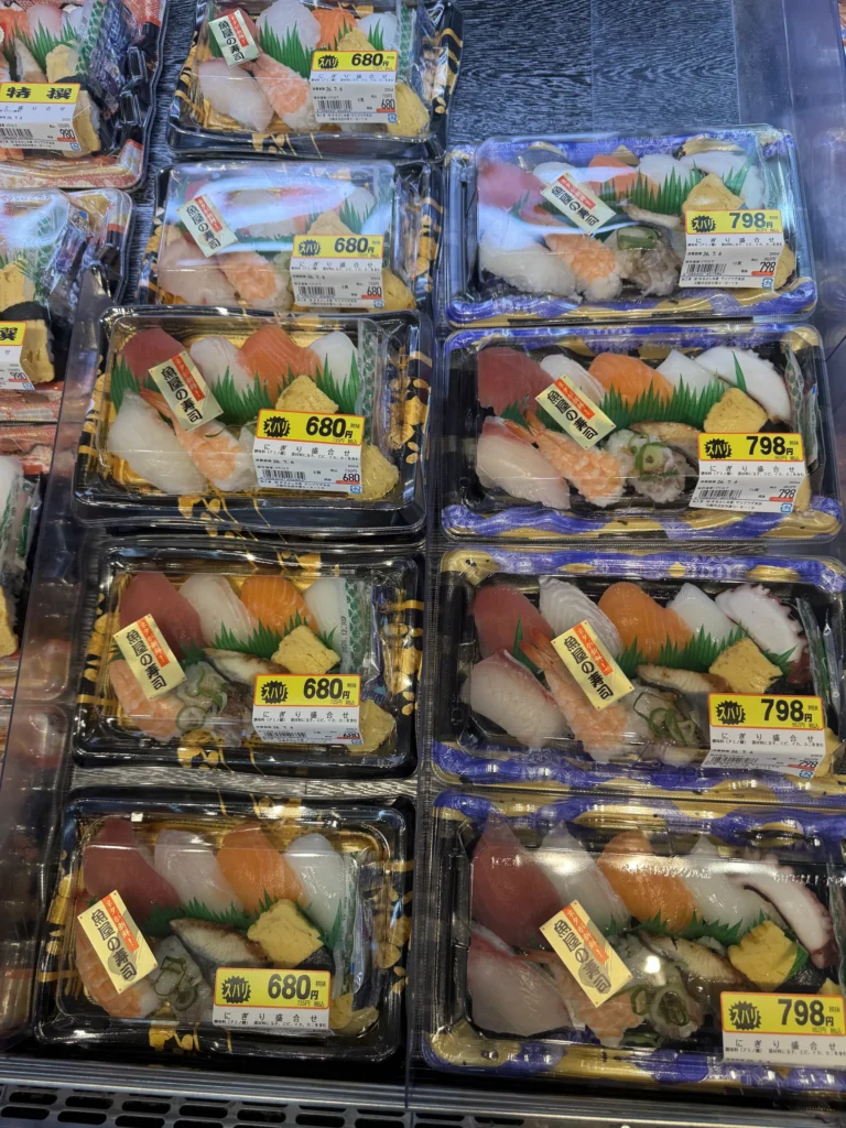 日本超市冷藏櫃裡的盒裝握壽司，標價 680 和 798 日幣