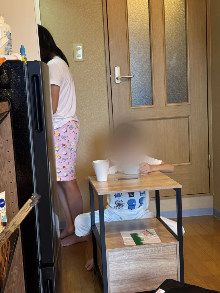 弟弟坐在套房的小桌子前吃午餐