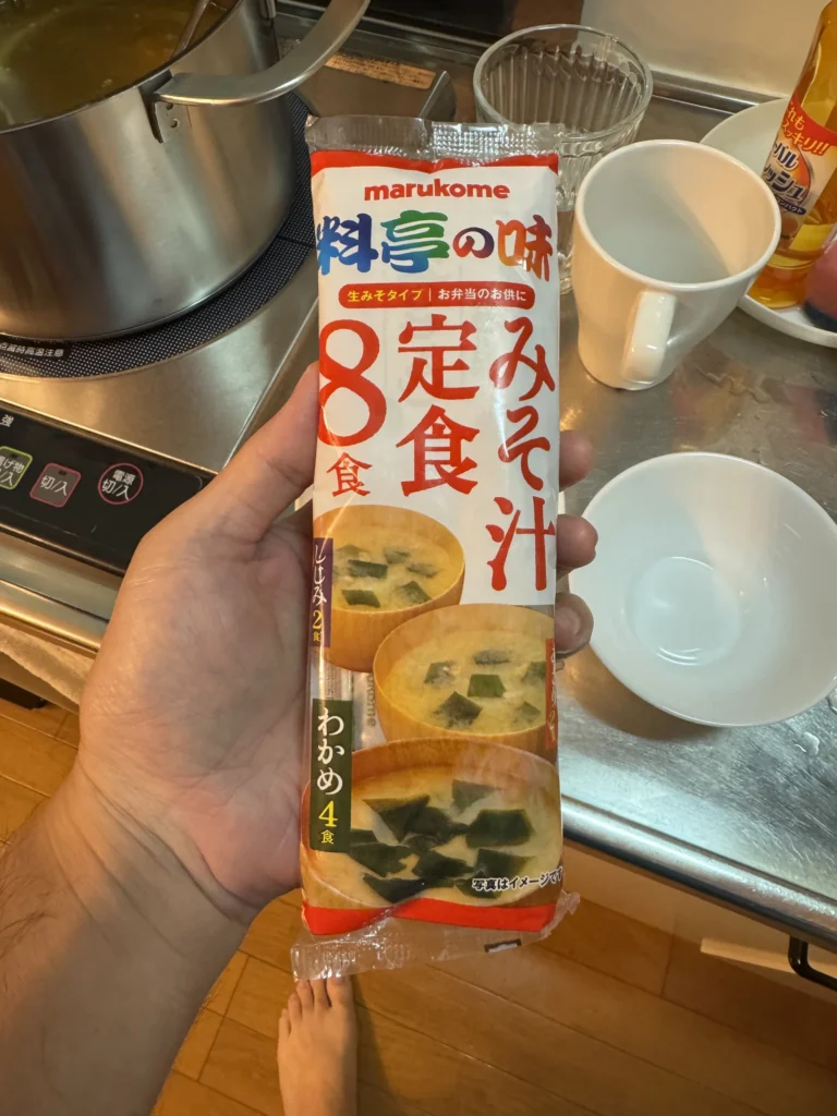 手上拿著 marukome 料亭の味的味噌湯，一包 8 食
